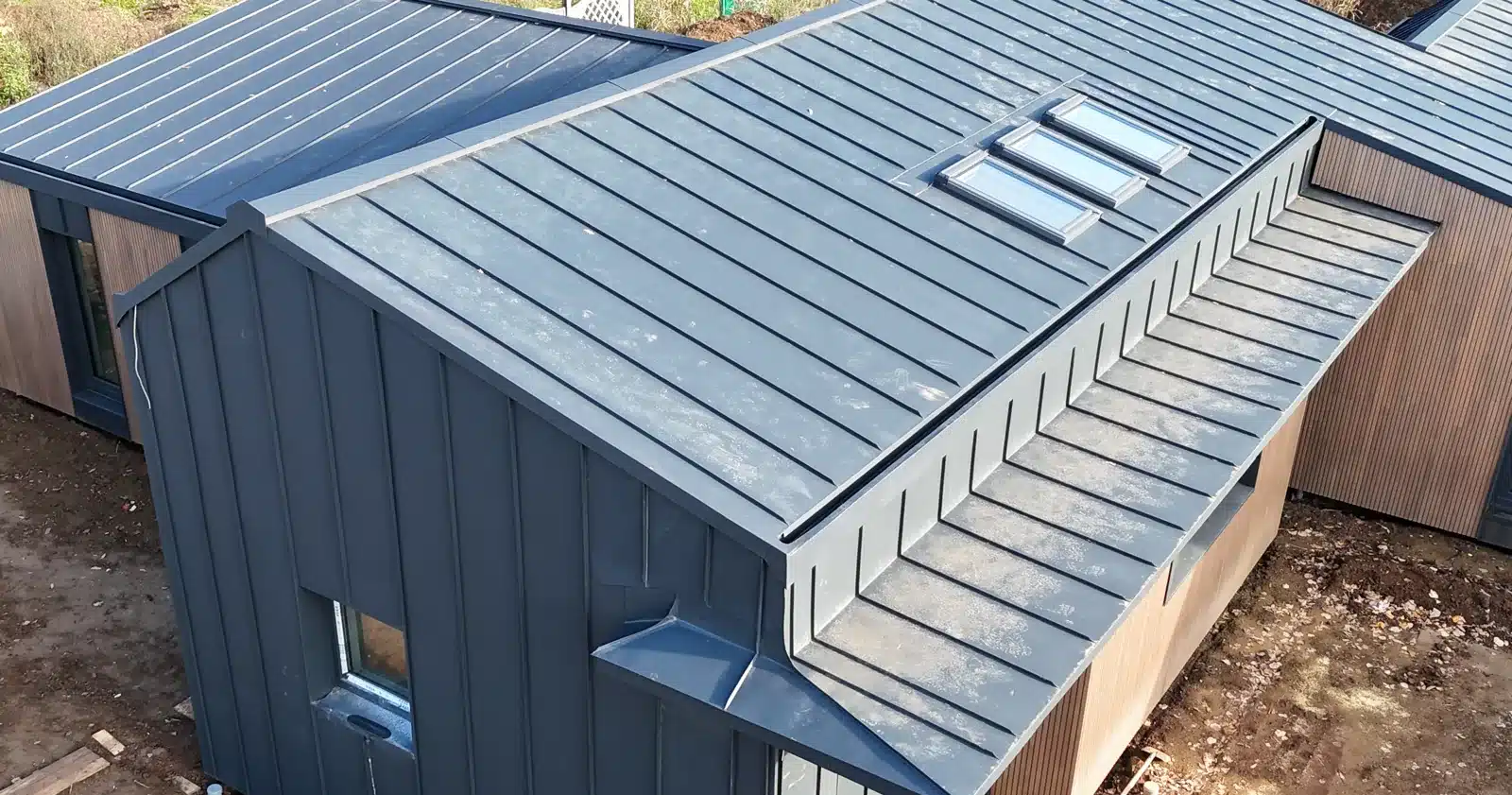 Trei ferestre de mansardă VELUX în linie pe un acoperiș din tablă fălțuită, montate de echipa Top Roofing în Ciolpani, Ilfov