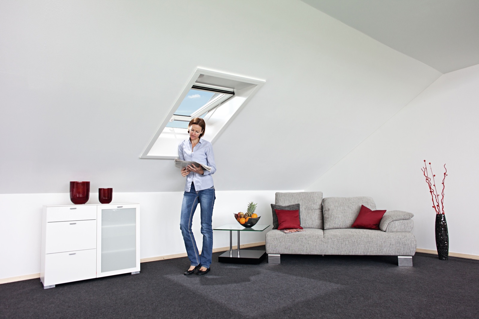 Fereastră de mansardă Roto din PVC alb într-o cameră de mansardă luminoasă
